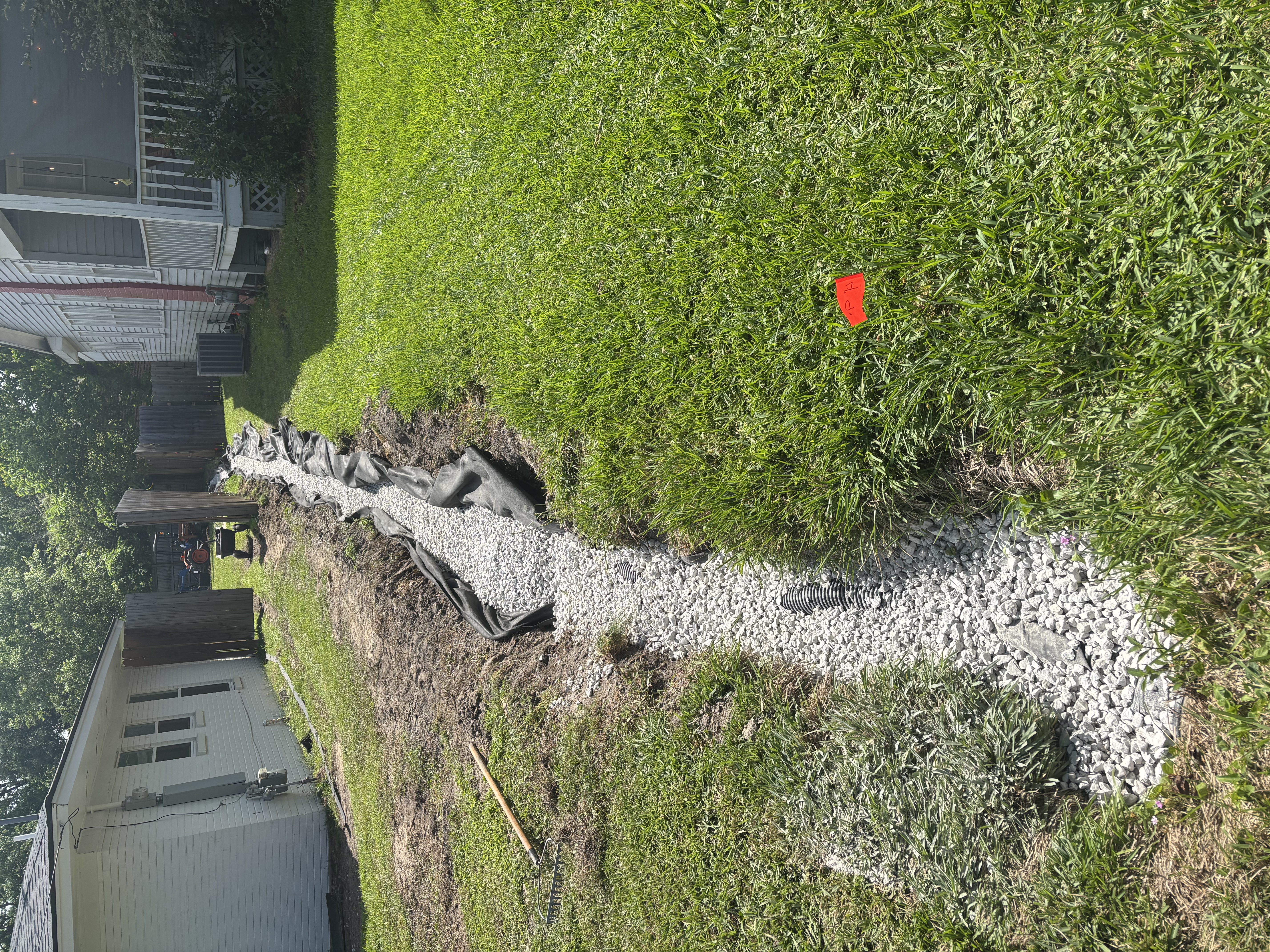 After - French drain installation with gravel, landscape fabric, and corrugated pipe in Baton Rouge