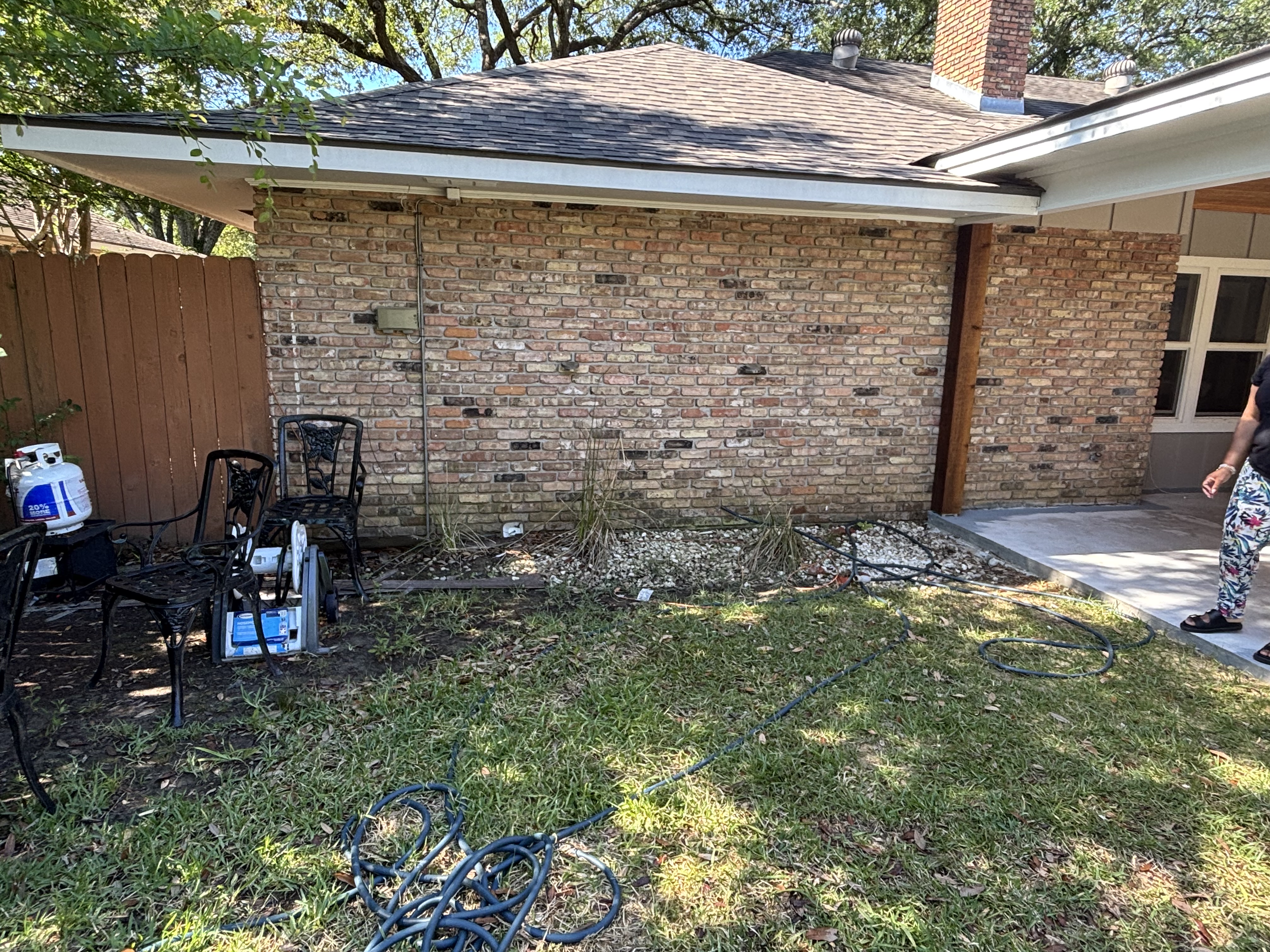 Before - bare backyard with brick wall, no landscape beds or plantings in Baton Rouge