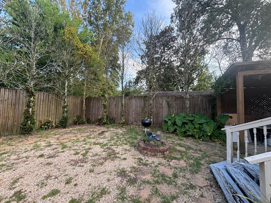 Before - patchy overgrown backyard with old fence