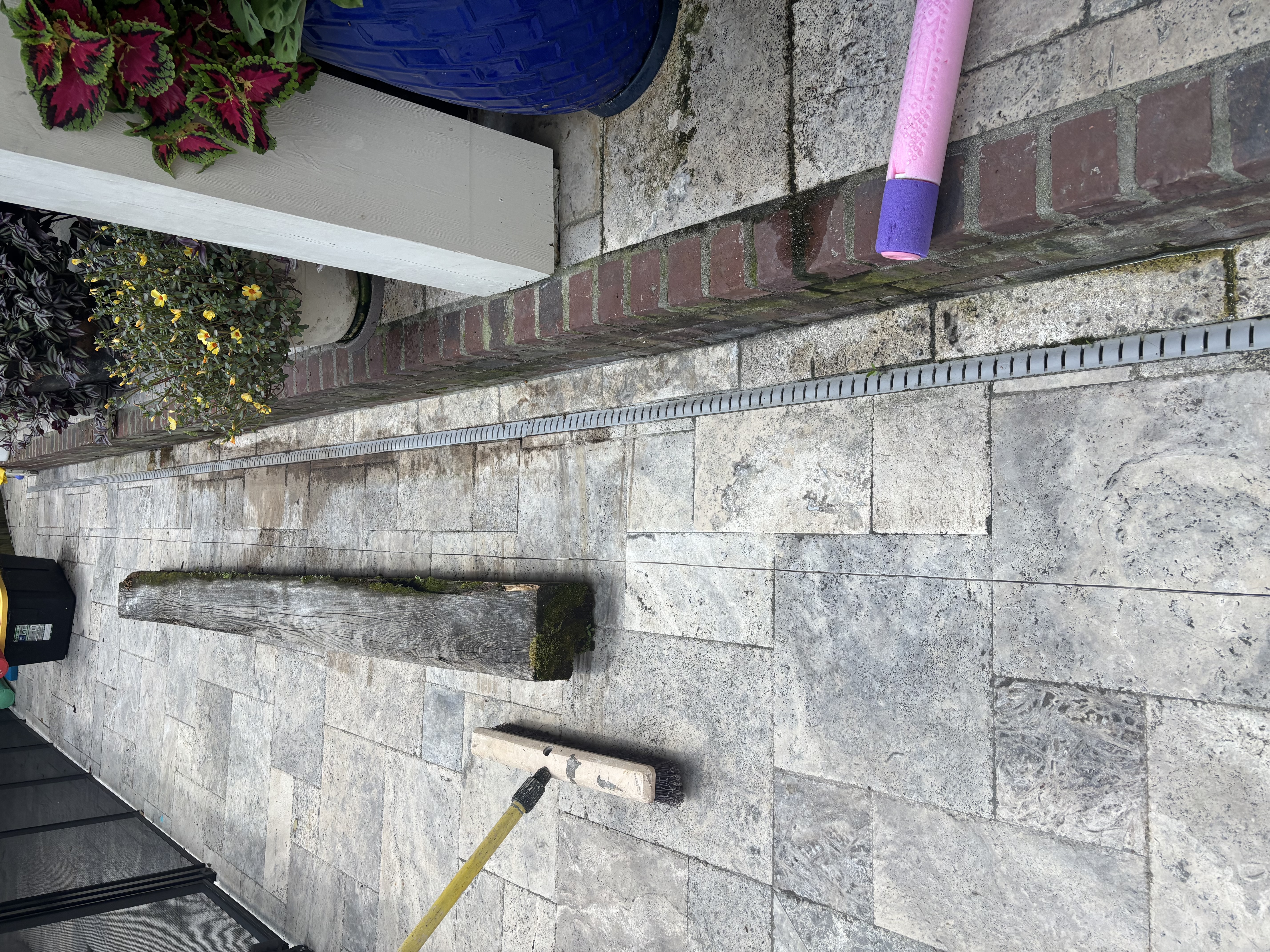 Before - aging timber beam serving as step edge on travertine walkway in Baton Rouge