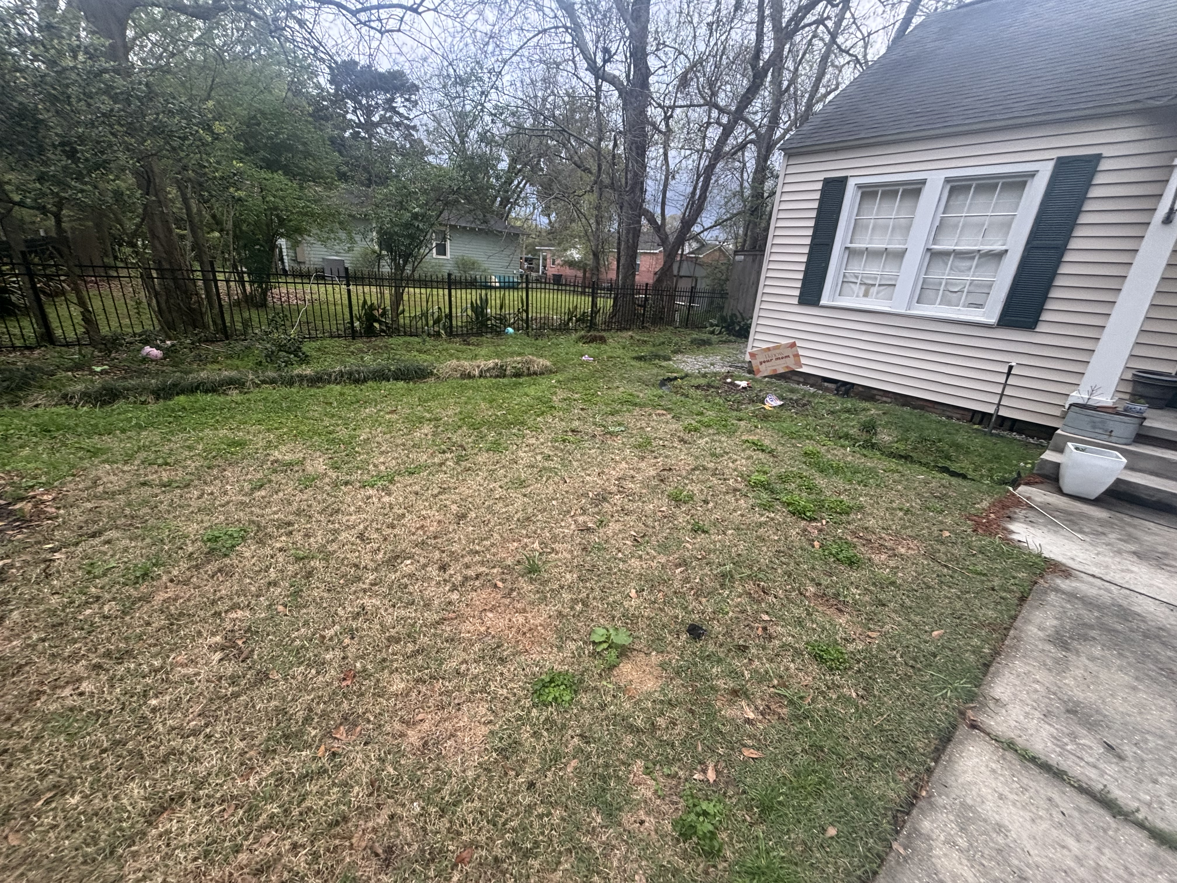 Before - bare front yard with patchy grass and no landscape beds in Baton Rouge