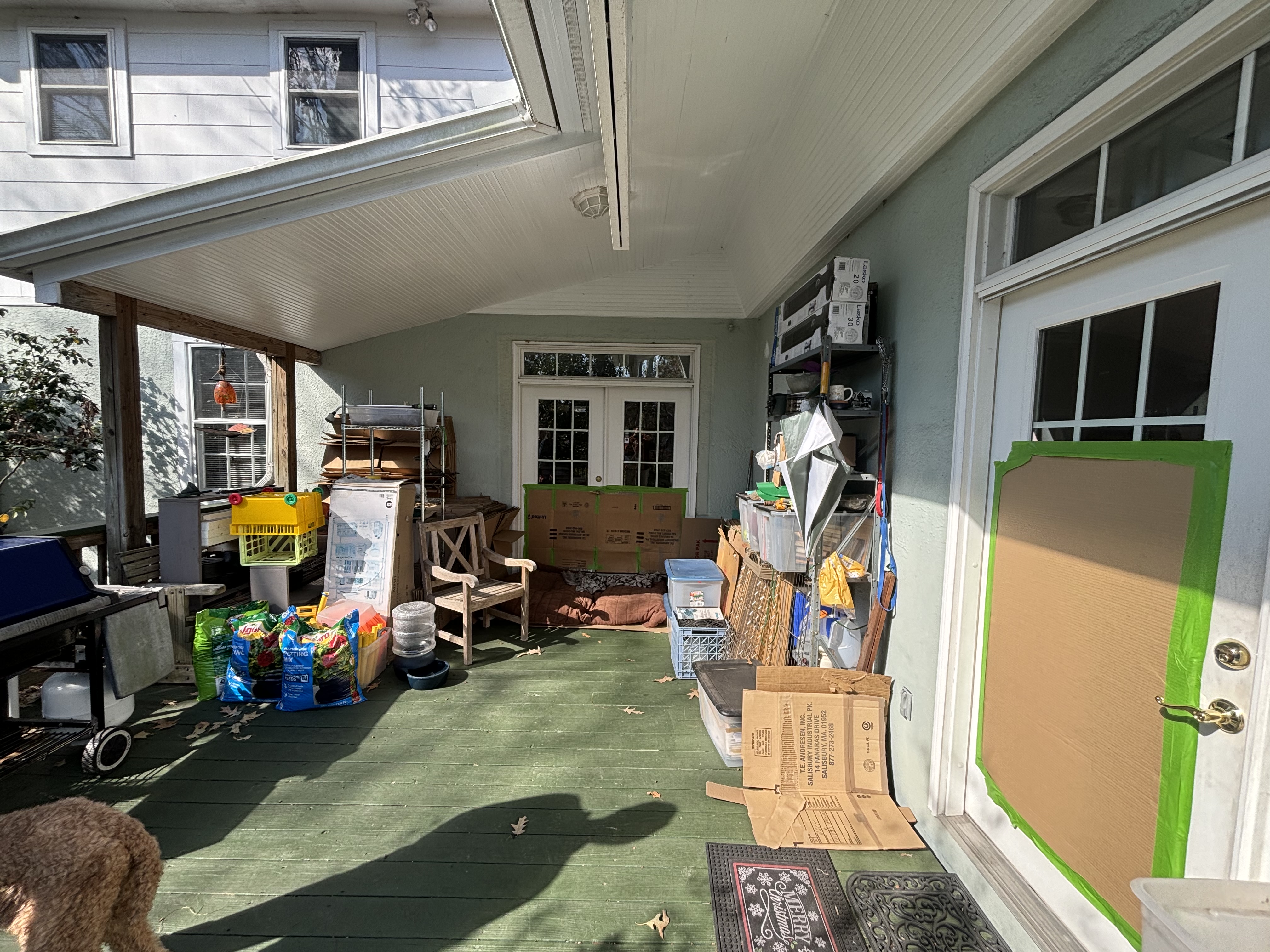 Before - cluttered open back porch with no screening