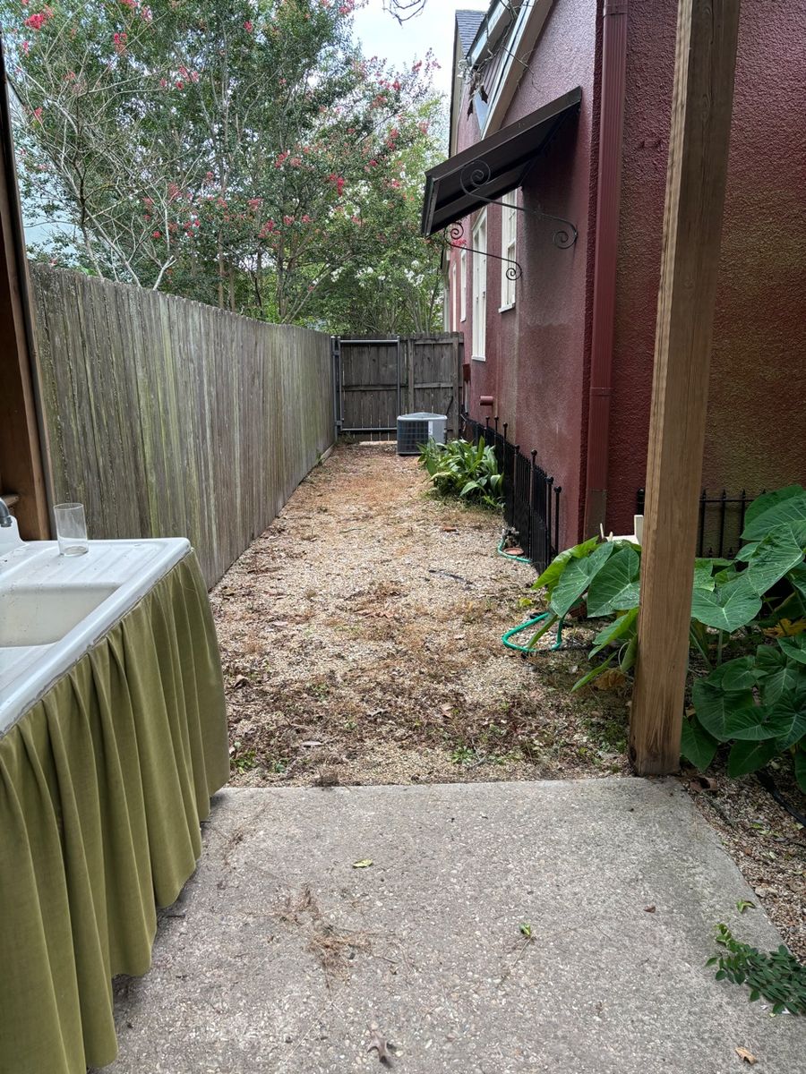 Before - bare gravel side yard with no grass or fence