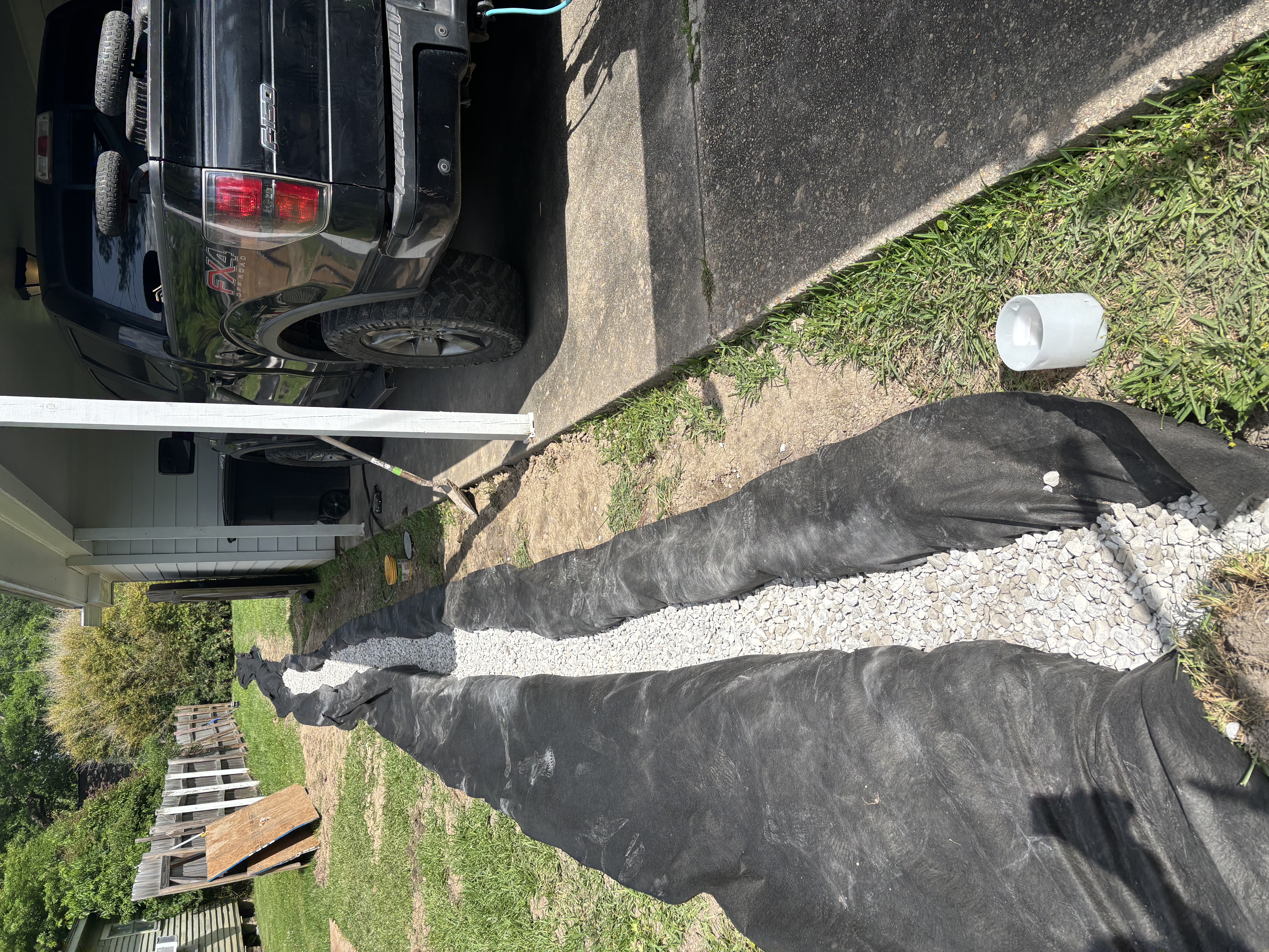 French drain with landscape fabric and gravel backfill along driveway - Baton Rouge