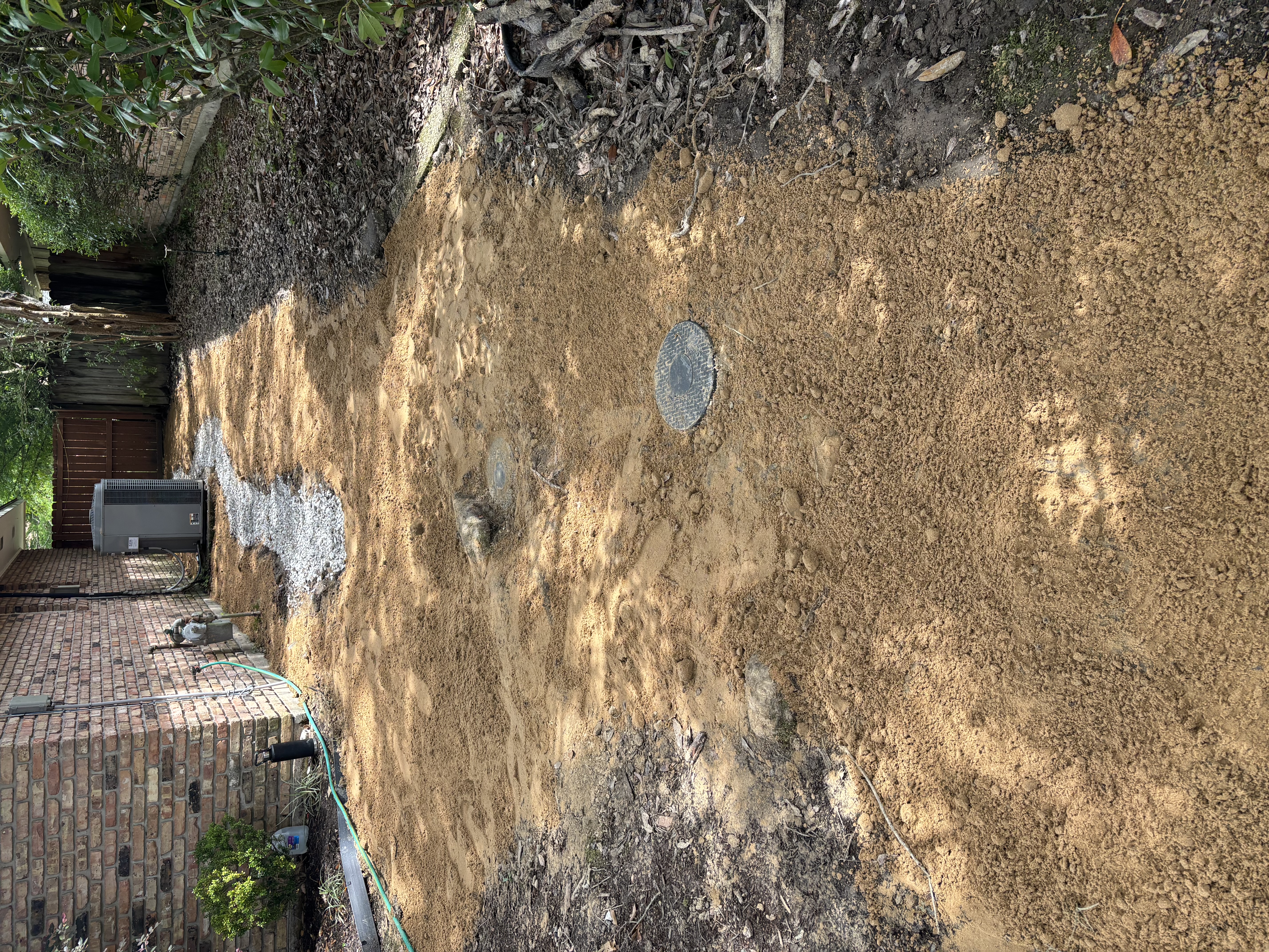 Open French drain with two emitter cleanouts after routing pipe under live oak roots - Baton Rouge drainage