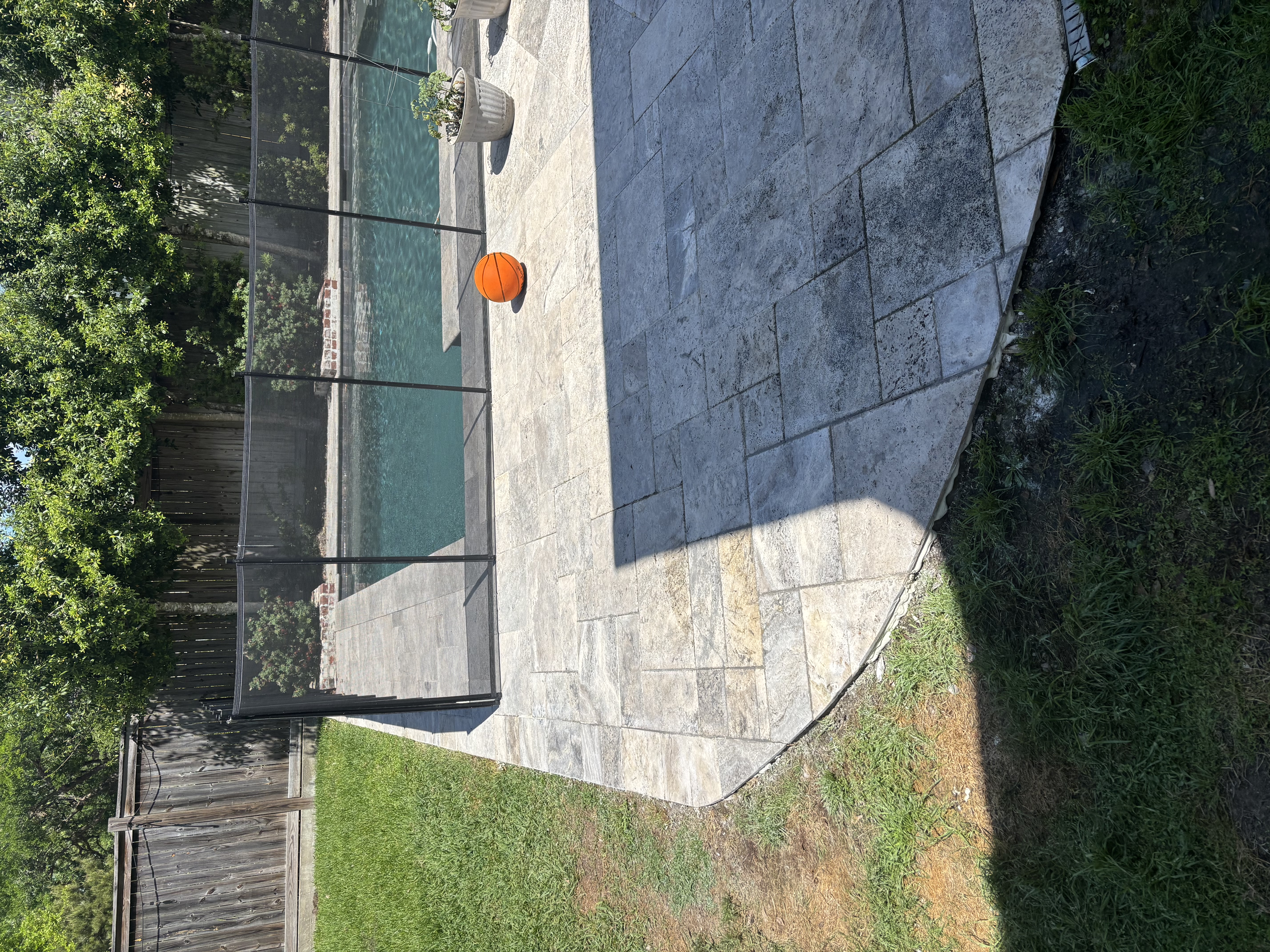 Silver travertine pool deck with paver border - Baton Rouge hardscape and masonry contractor